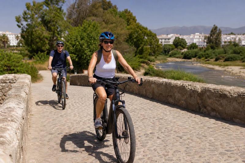 E-bike riders crossing a river bridge in Marbella